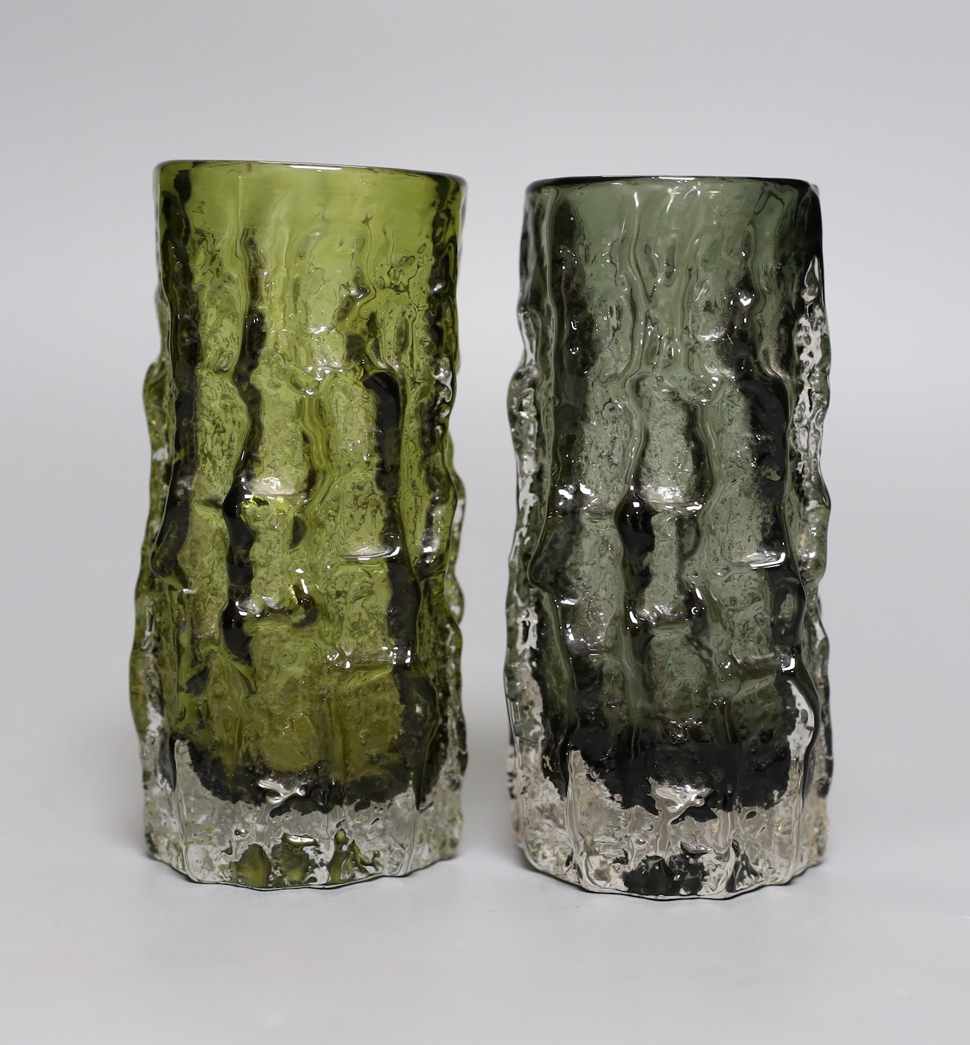 Two Whitefriars 'bark' cylinder vases, model 9689 designed by Geoffrey Baxter in ‘sage’ and 'willow' glass, each 15cm high.